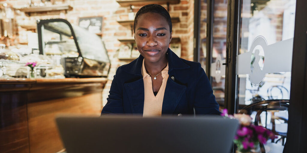 Small business owner reviewing brand messaging and website copy to check for consistency across marketing channels