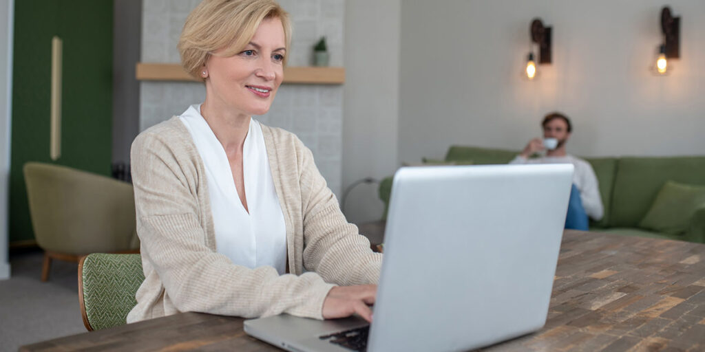 Small business owner reviewing website copy, social media posts, and emails to assess consistency of brand voice across channels