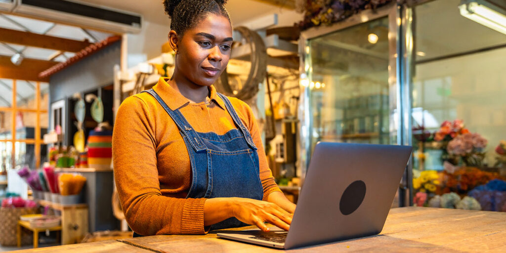 Business owner researching competitor websites and search rankings to assess market positioning during an annual marketing review