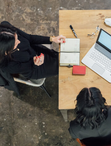 Ontario small business owner at a desk transitioning marketing responsibilities to a fractional marketing partner with a laptop and notebooks open