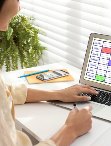 Ontario small business owner planning a content calendar on a laptop with a notebook and coffee on the desk